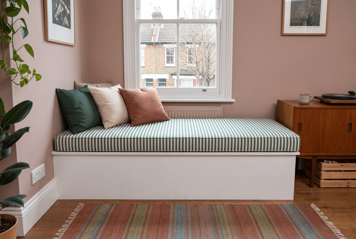The same angled bay window seat with a blue-grey linen cushion
