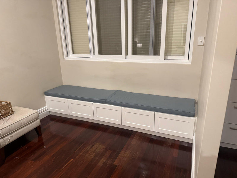 Customer photo: blue-grey cushions along a white window storage bench
