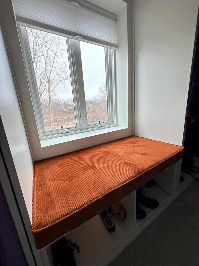 Customer photo: rust corduroy cushion in a window nook above shoe storage