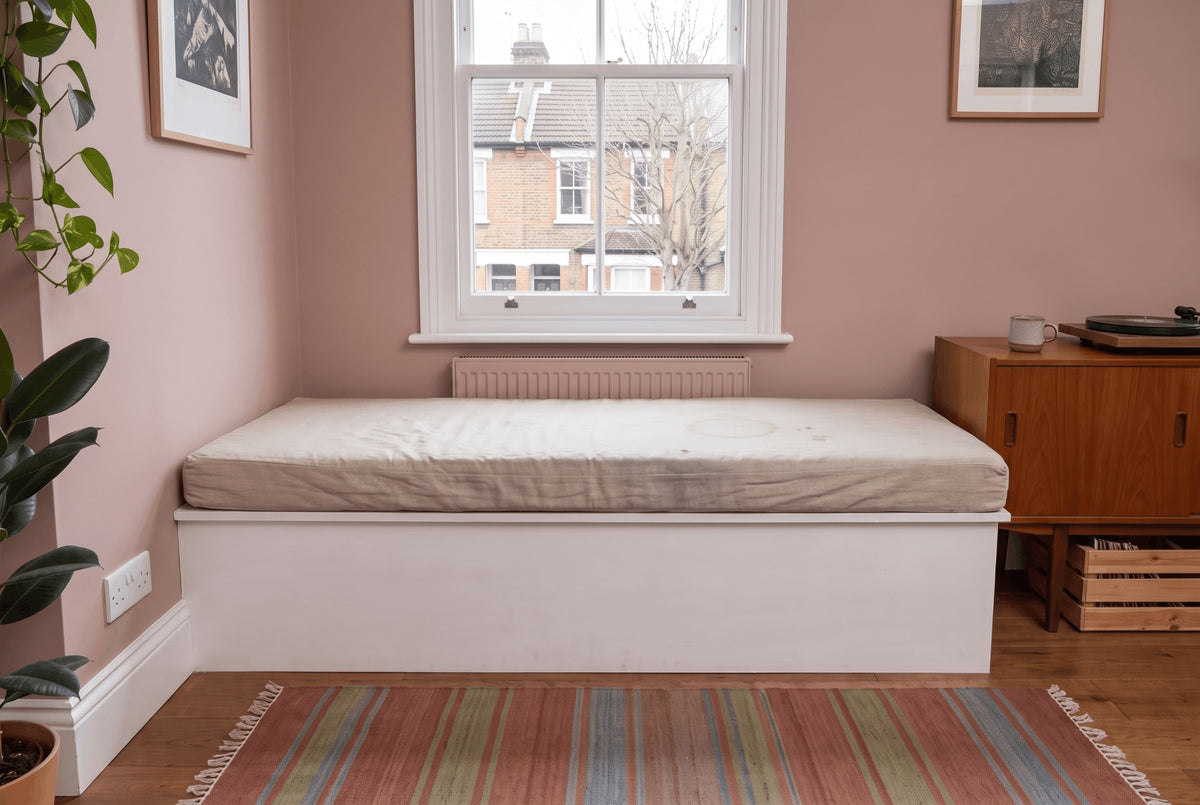 Angled bay window seat with an oatmeal linen cushion cut to the bay